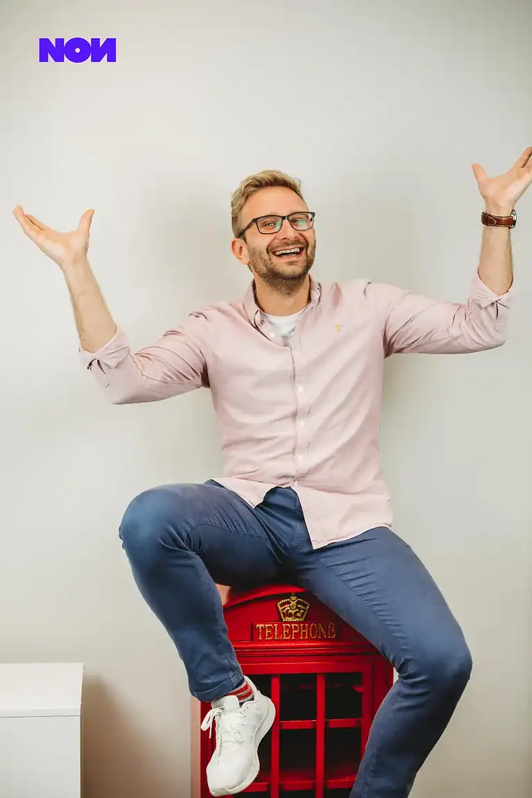 Rafał Moszkowcow Chomsky, International SEO Specialist at non.agency, laughing in a blue blazer