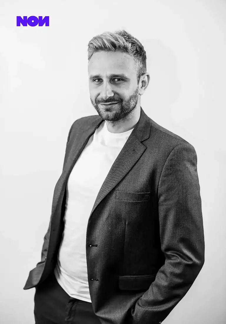 Rafał Moszkowcow Chomsky, International SEO Specialist, black-and-white portrait in a grey blazer