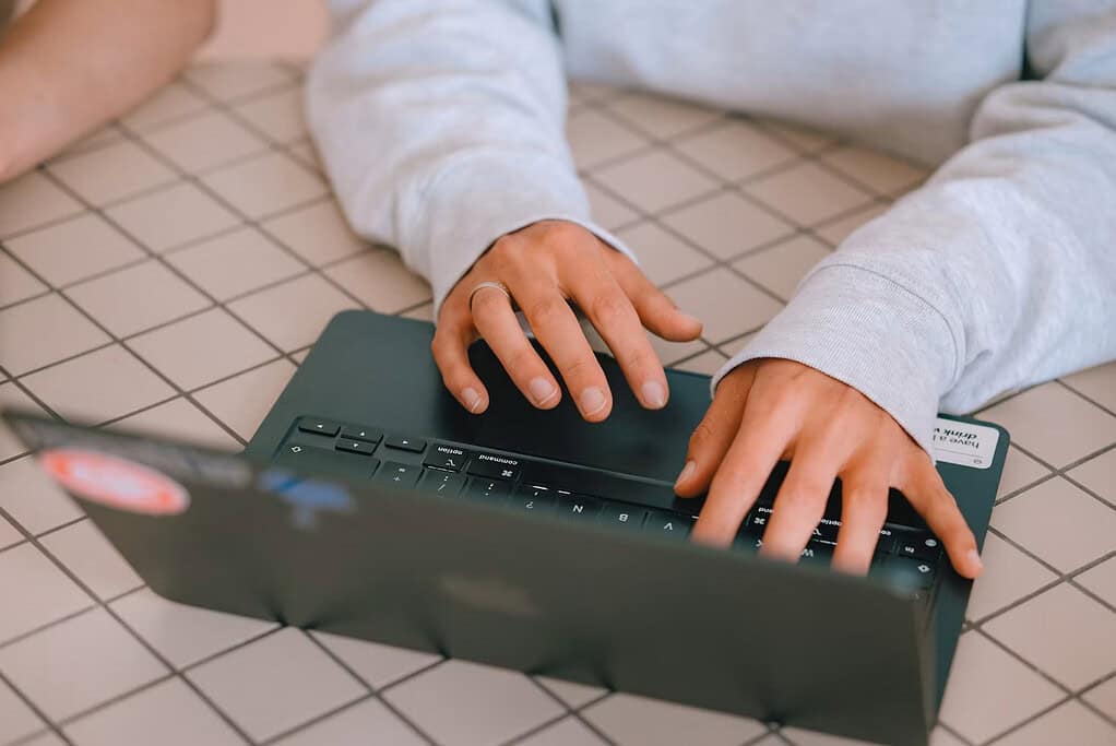 Person typing on a laptop keyboard at a desk