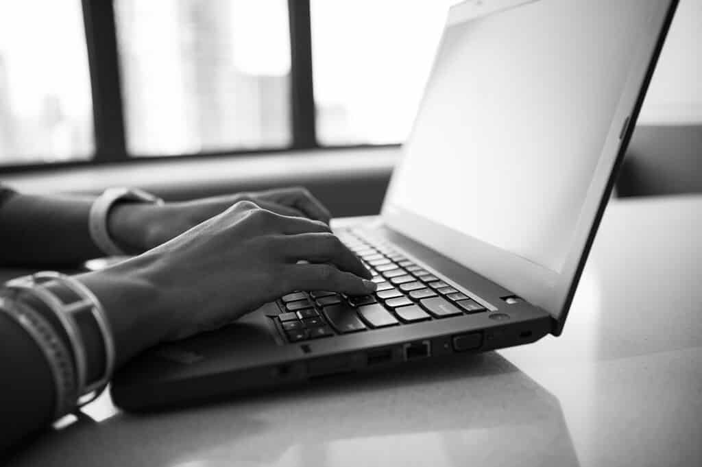 Close-up of a person typing on a laptop keyboard